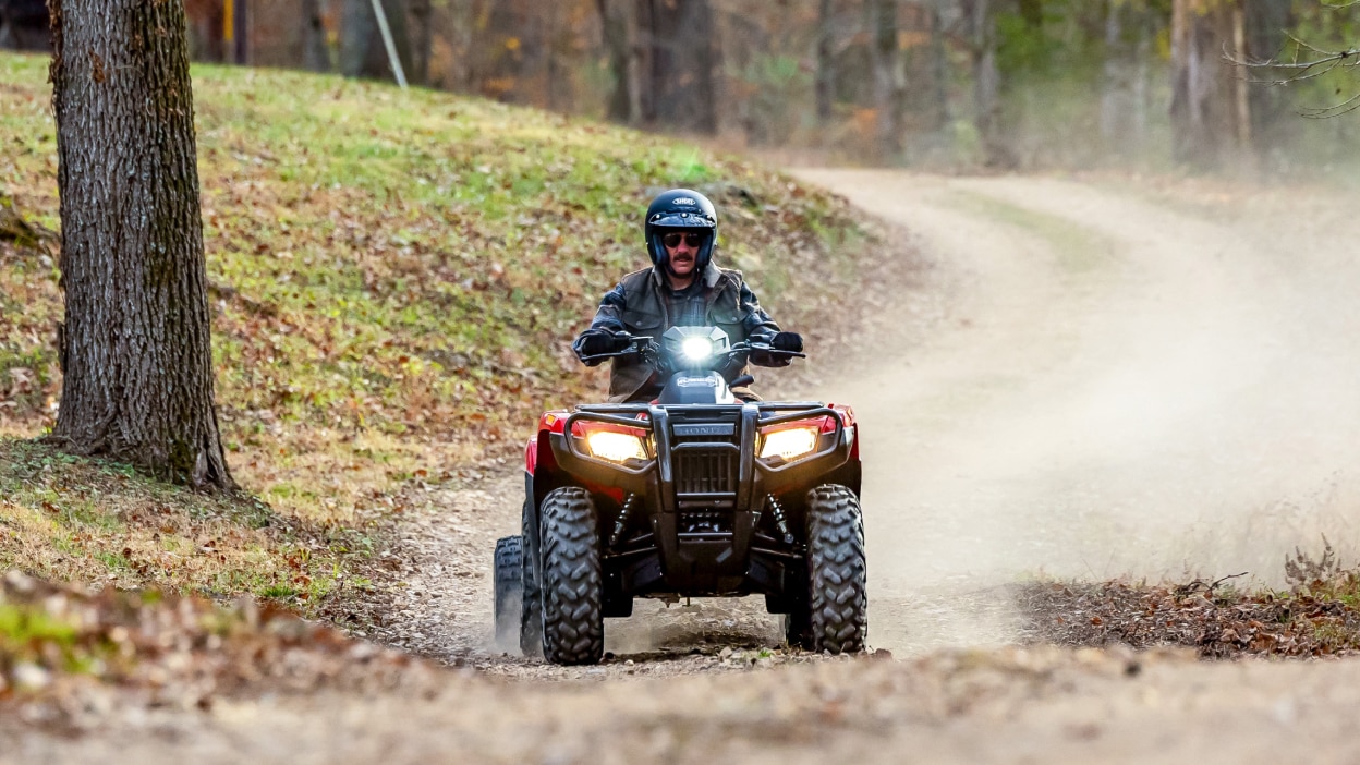 Un pilote sur une Honda Rubicon soulevant la poussière.