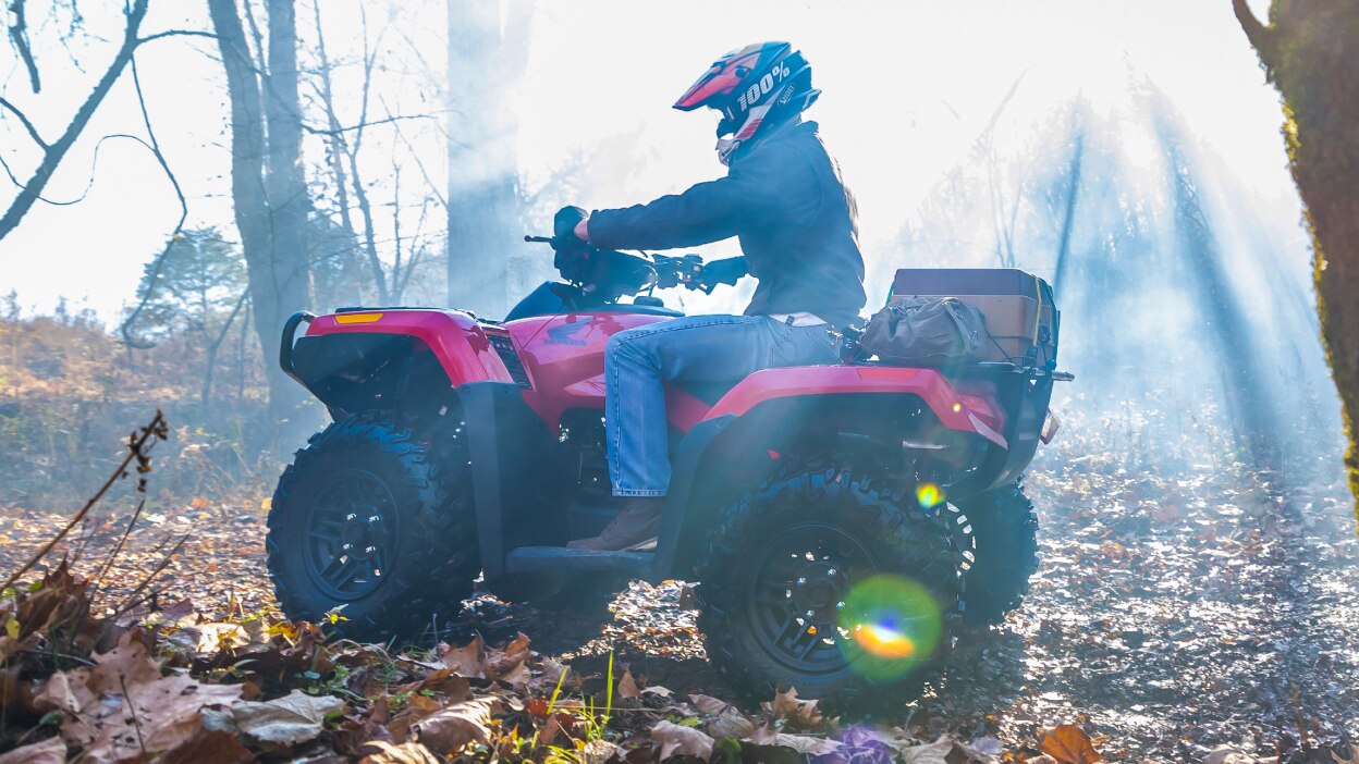 Vue latérale d'un homme conduisant un Rubicon 700 sur un sentier avec des items chargés sur le système de porte-bagages Pro-Connect<sup>MC</sup>