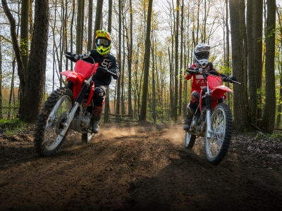 Two riders on Honda Trail bikes in the woods