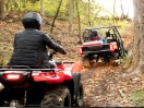 Riders in a Honda SxS and a on a Honda ATV riding on a trail in safety gear 