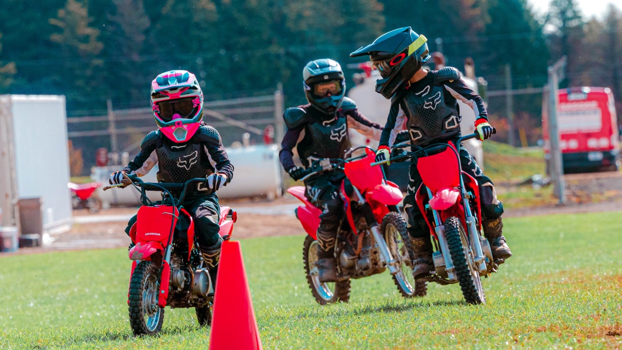 Three Junior Red Riders with a cone in front