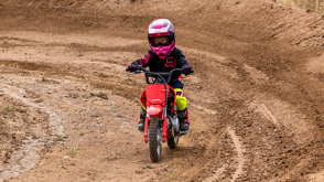 A rider on a Honda Trail motorcycle on a dirt track