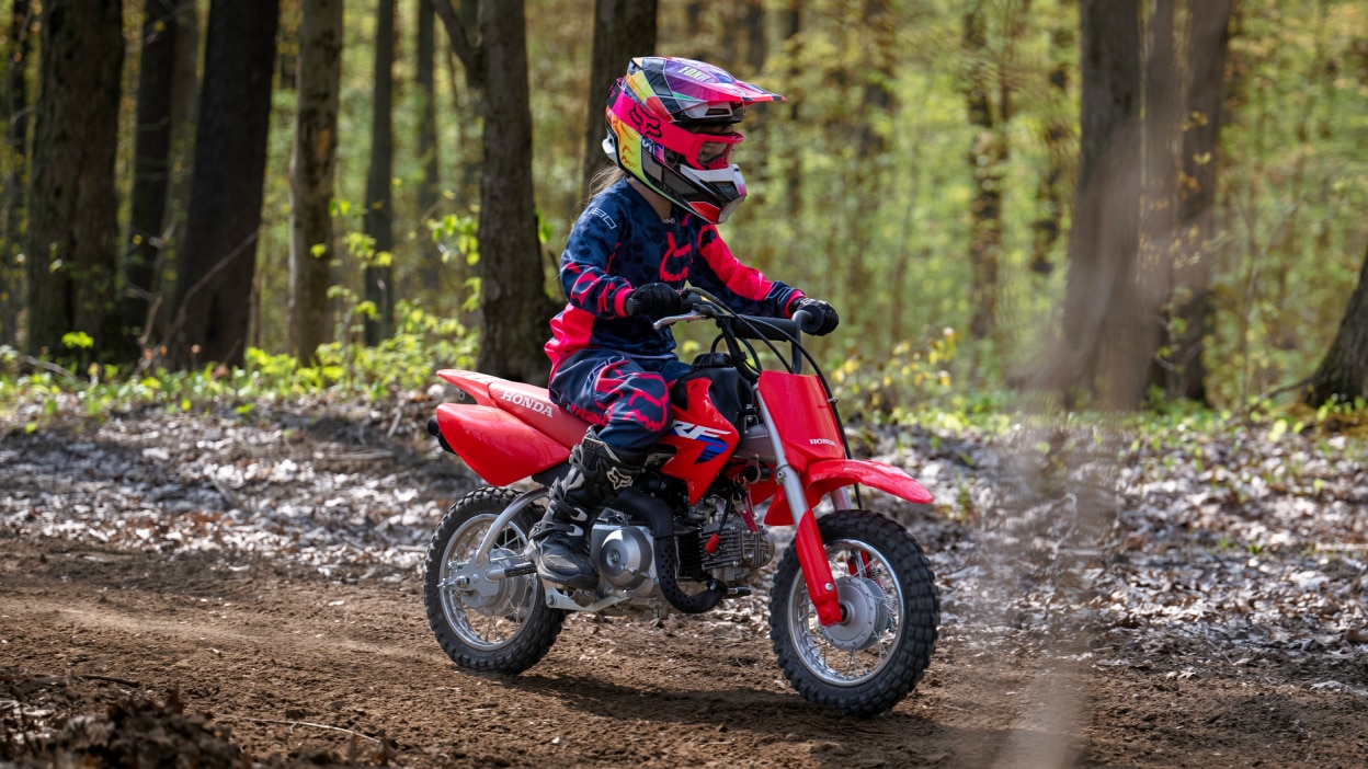 A young rider on a Honda CRF50F