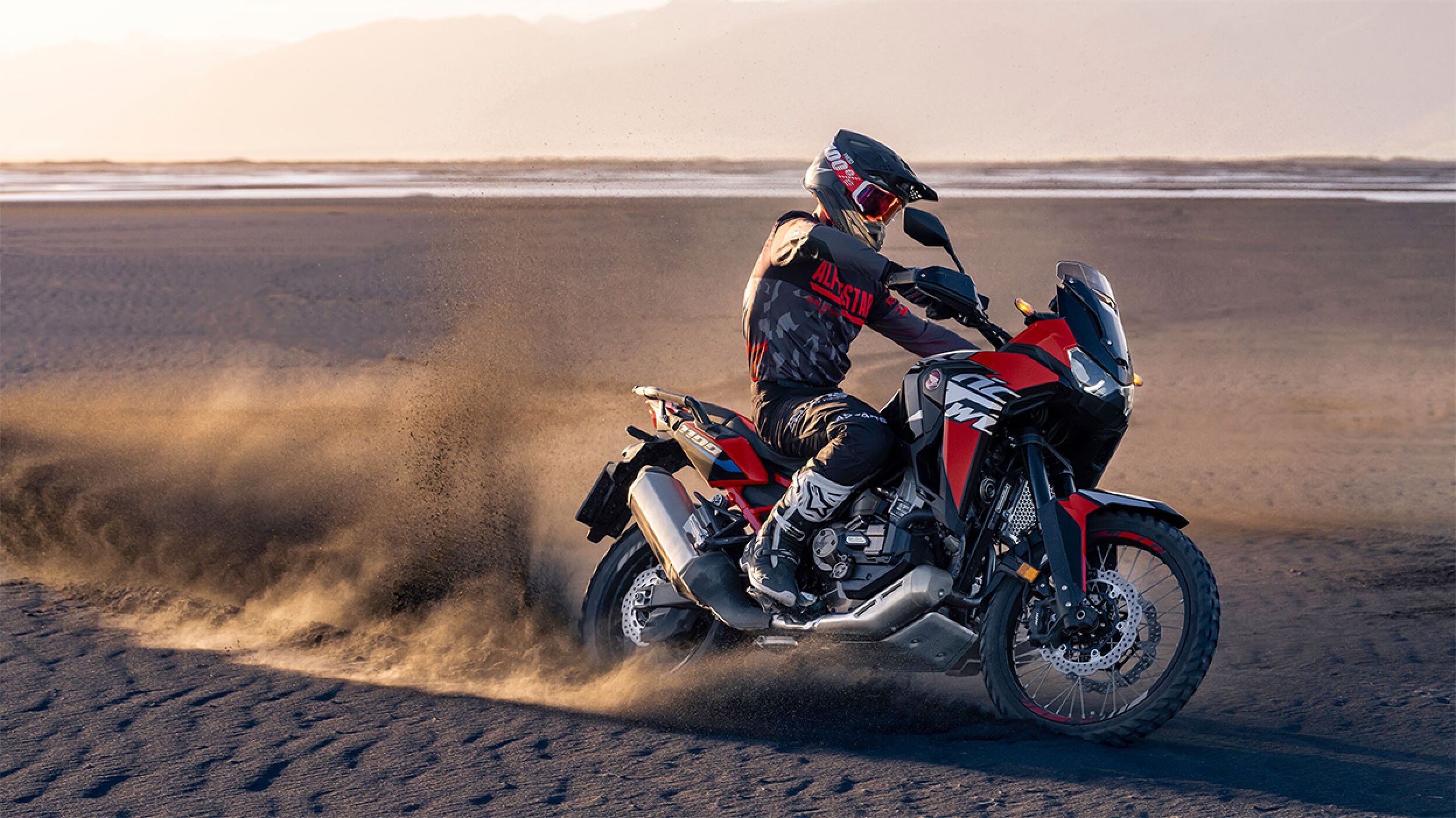 A professional rider on an Africa Twin kicking up dust
