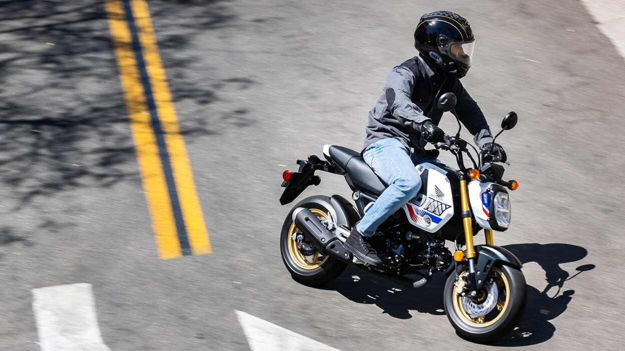 Coureur sur un vélo jaune faisant un virage à gauche sur la route. Angle de route élevé.