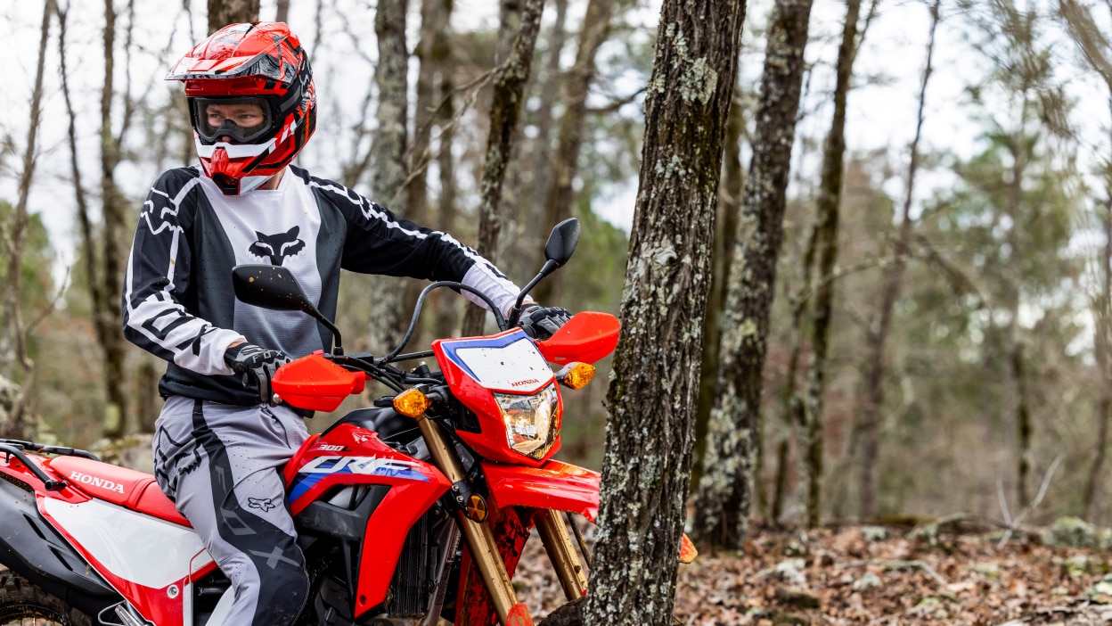A rider paused in the woods on a Honda CRF300L