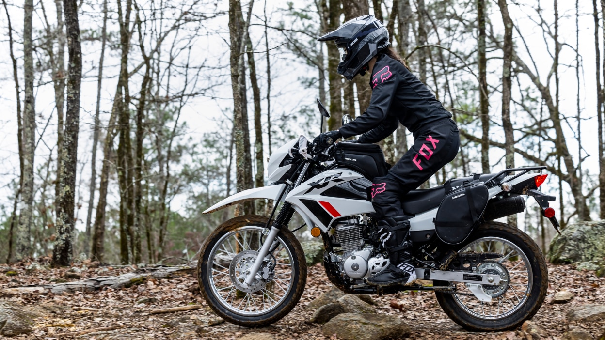 A rider in the woods on a Honda XR150L