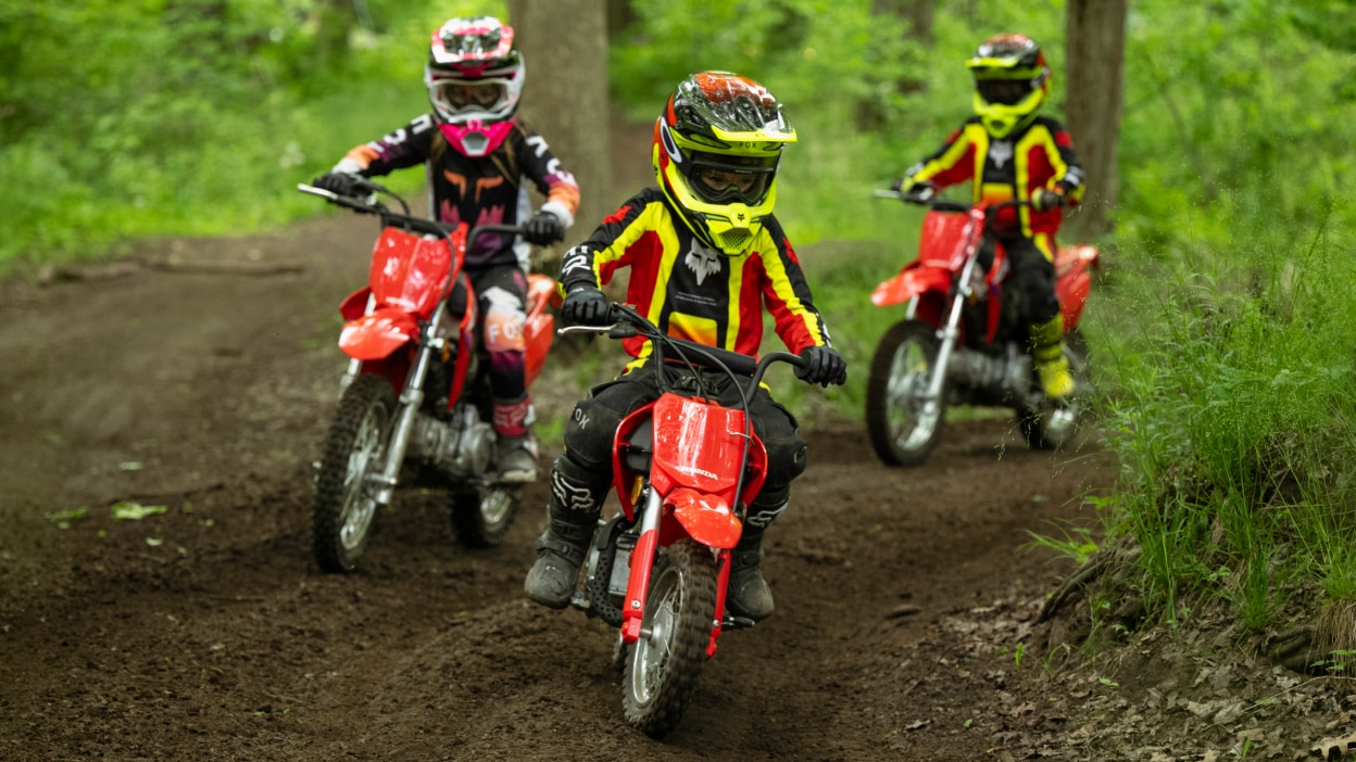 Three young riders on dirt track in forrest.