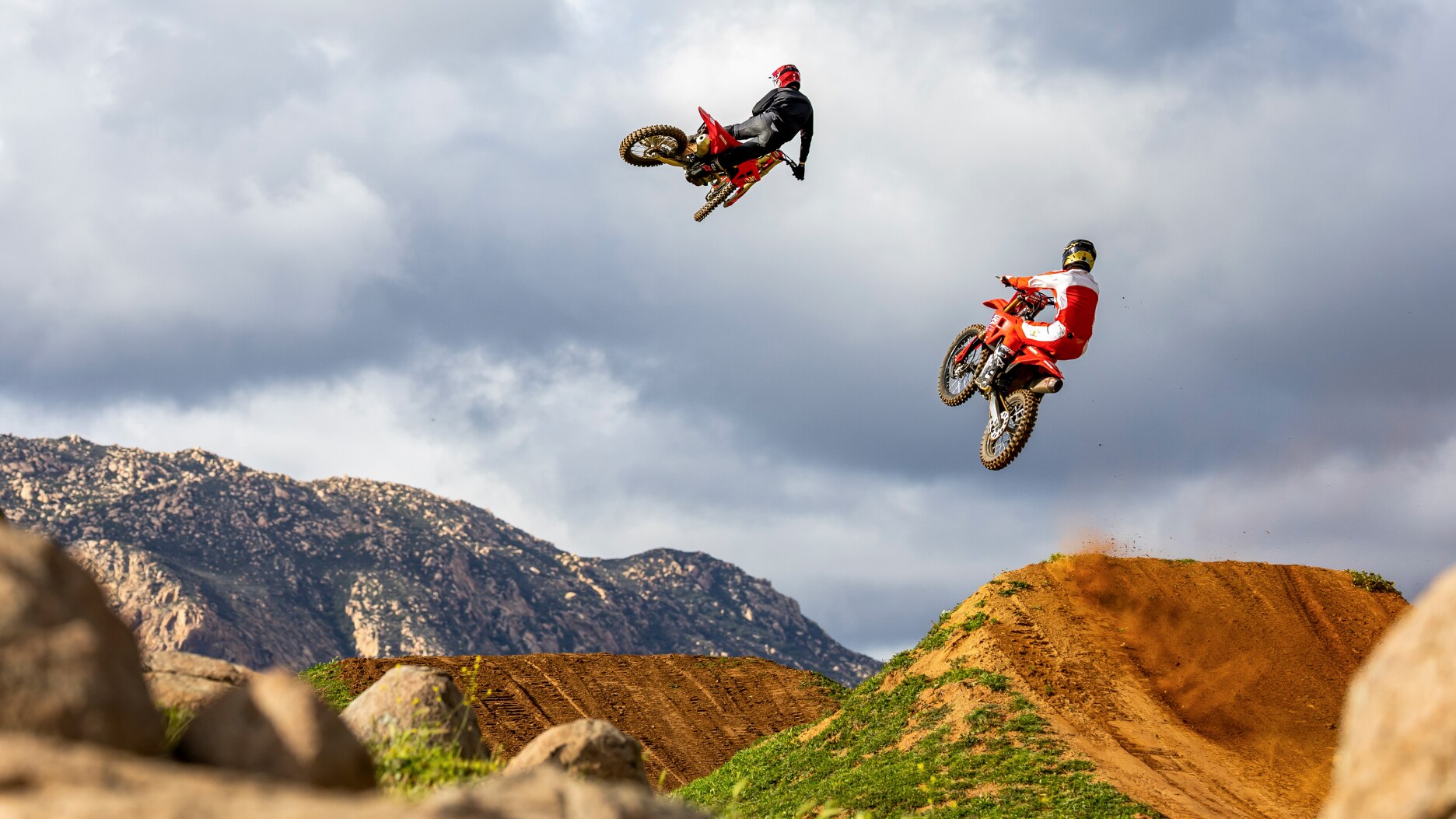 Two riders mid air. Back facing.