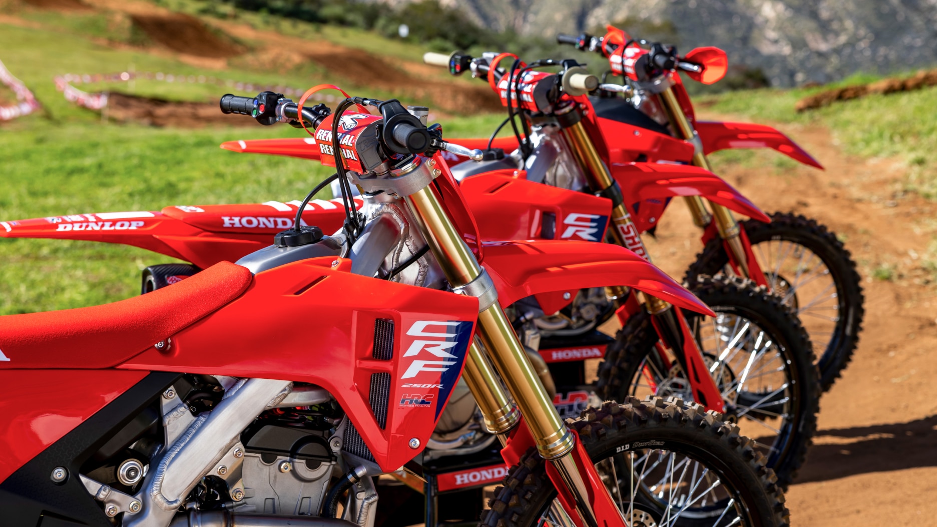 Close up of handles of three competition bikes facing right.