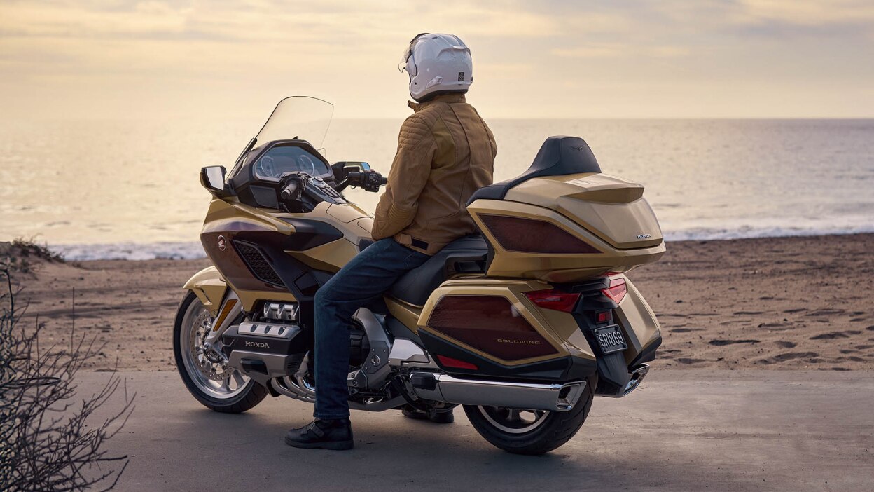 Rear view of rider stationary on Gold Wing. Sea in background.