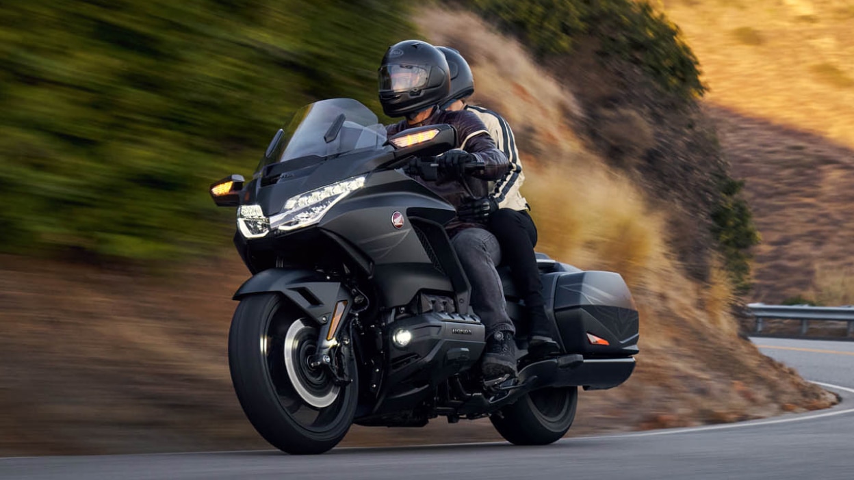 Angle avant du pilote et du passager sur Gold Wing sur route. Fond de montagne.