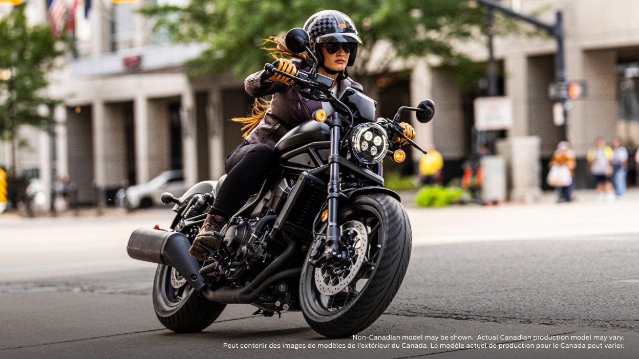 Rider turning left in road. Building and trees in background. Non-Canadian model(s) may be shown. Actual Canadian production model(s) may vary.
