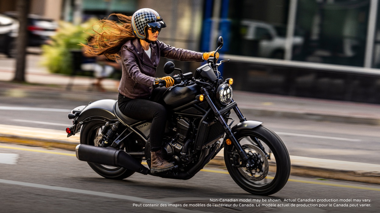 Rider on road going right. Building and sidewalk in background. Non-Canadian model(s) may be shown. Actual Canadian production model(s) may vary.