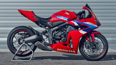 Une moto sport Honda rouge garée sur une surface asphaltée.
