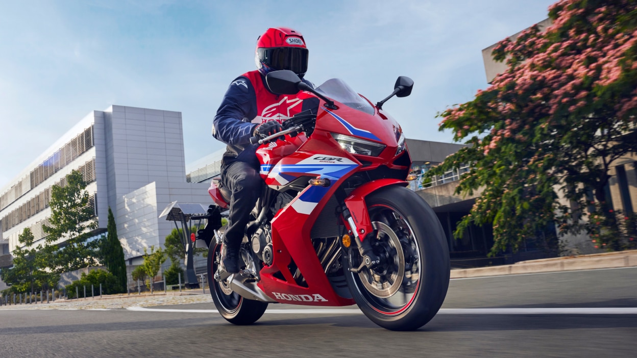 Rider on CBR650R in city landscape.