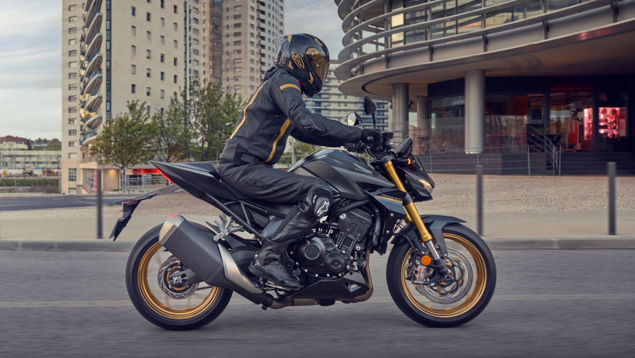 Pilote allant à droite sur CB1000SP dans un paysage urbain.