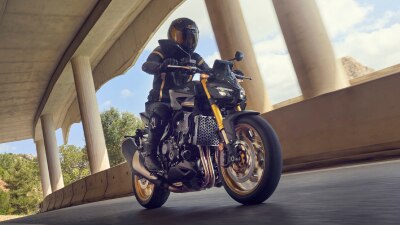 Rider on CB1000SP under bridge on road.