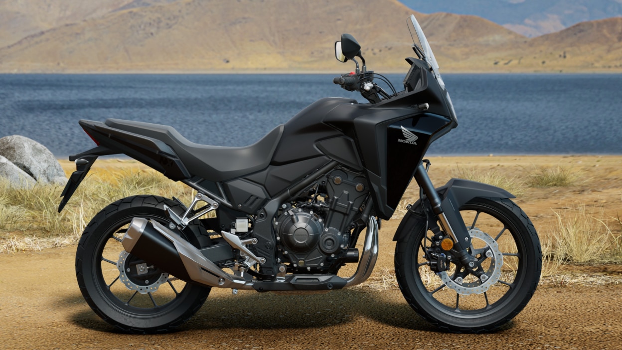 Angle droit du NX500 sur chemin de terre. Lac et collines en arrière-plan.