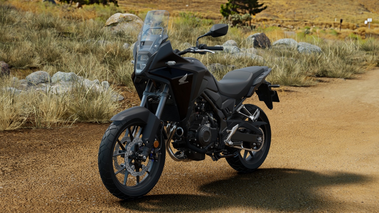 Angle gauche du NX500 sur chemin de terre. Des parcelles d'herbe et de rochers en arrière-plan.