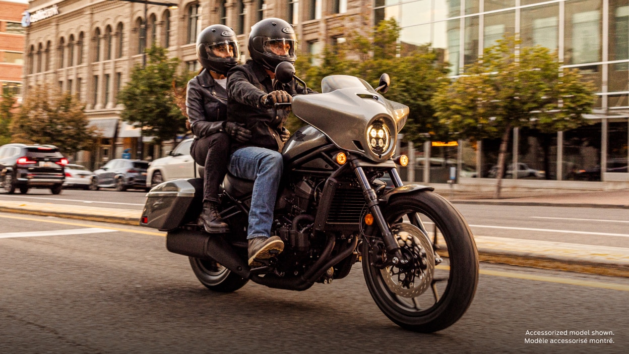 Rider going left on street on grey Rebel.