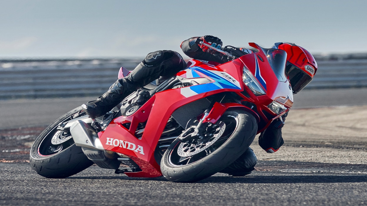 Un pilote sur une CBR1000RR-R Fireblade effectue un virage serré à gauche sur circuit.