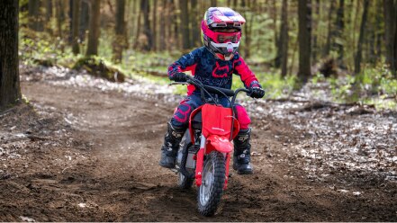 Young rider on dirt track. Front facing.