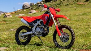 A parked CRF450RX ina grassy field