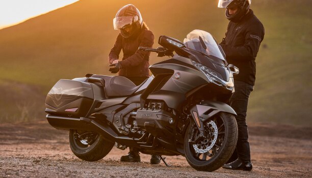 Image fixe de droite d'une Gold Wing. Des motards casqués se tiennent derrière la Gold Wing.