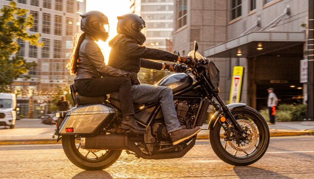 Two riders going left on street. Accessorized model shown.