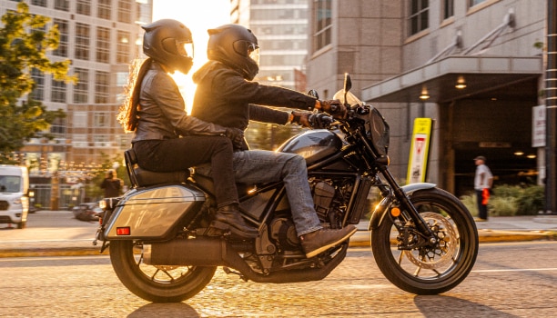 Two riders going left on street. Accessorized model shown.