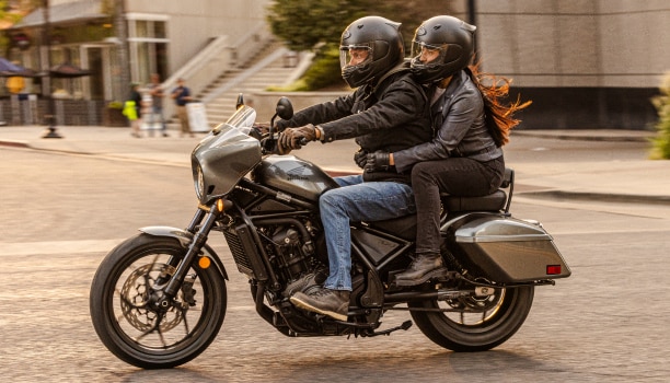 Two riders going right on street. Accessorized model shown.