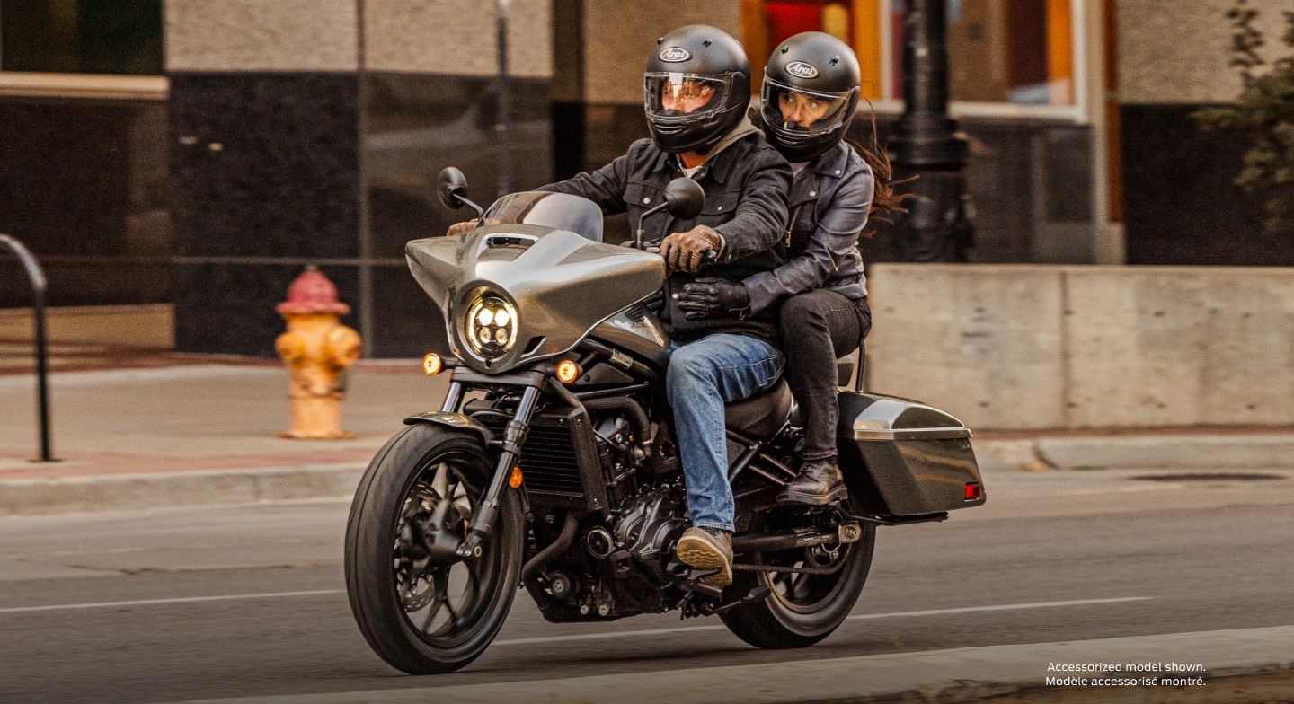 Deux motards roulant à gauche dans la rue. Modèle accessorisé montré.