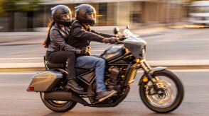 Two riders going left on street. Accessorized model shown.