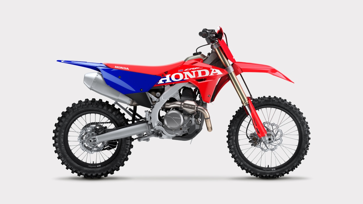 Vue de profil d'une moto tout-terrain rouge et bleue.
