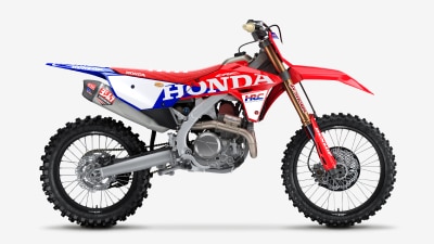 Side profile of a red and white Honda motocross motorcycle.
