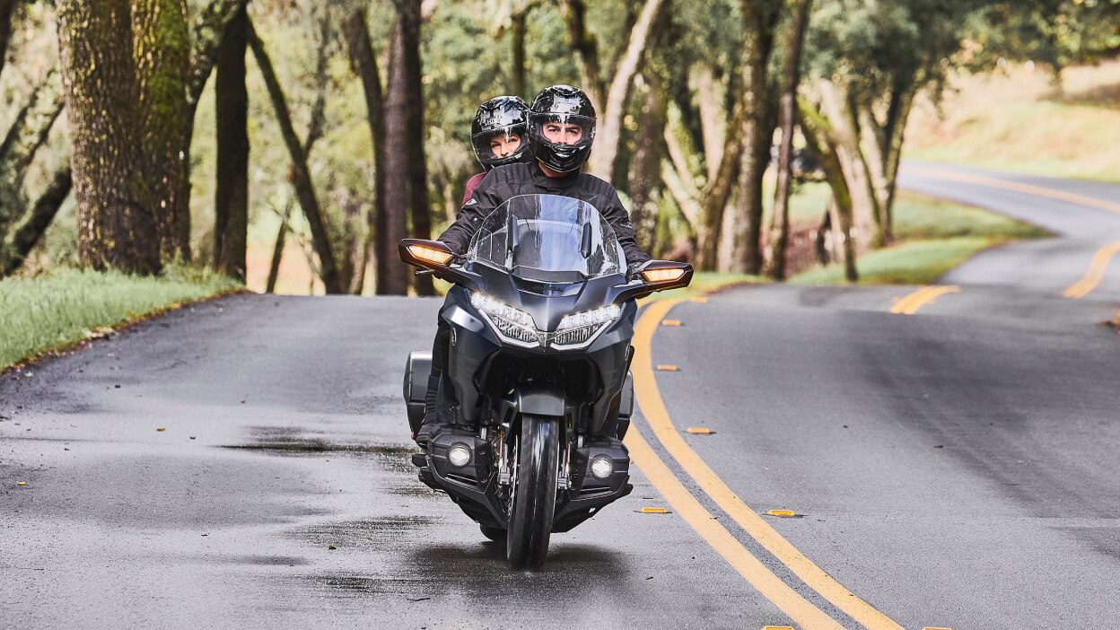 Une moto de tourisme roulant le long d'une route côtière.