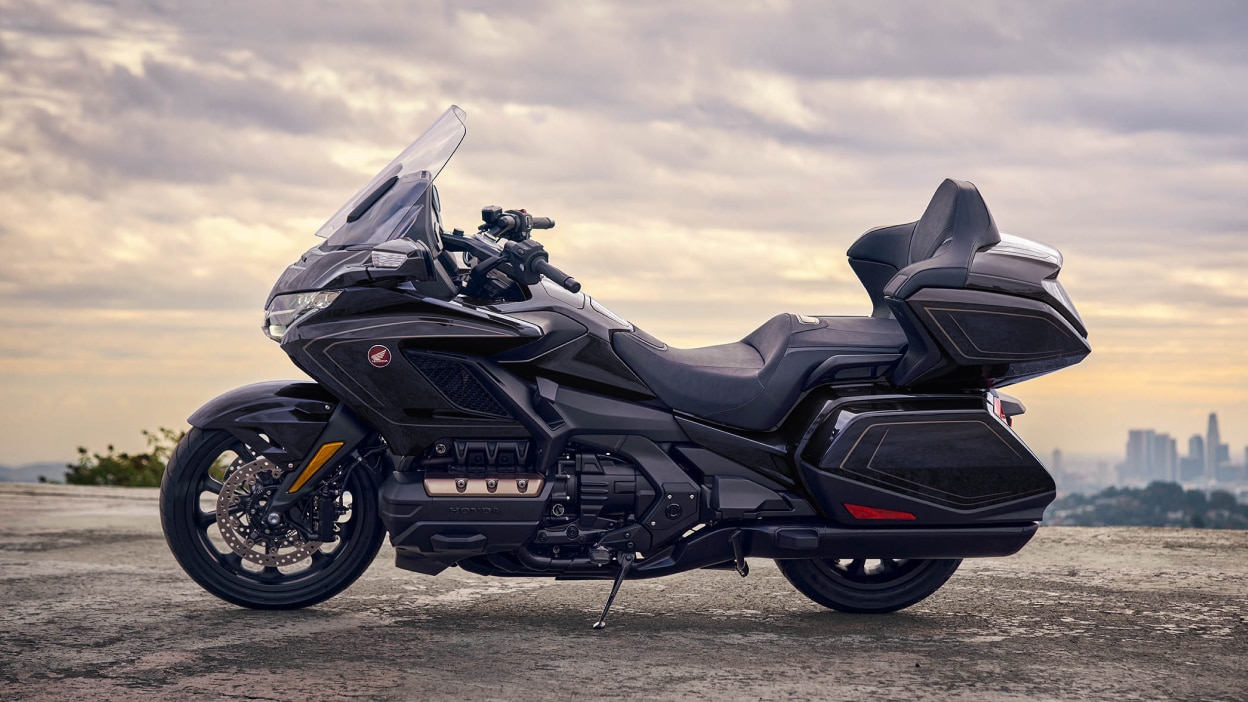 Profil latéral d'une moto de tourisme garée devant un paysage pittoresque.