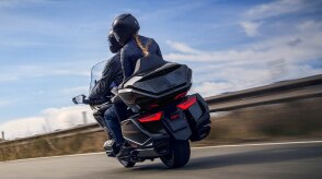 Un motard se penchant dans un virage serré sur une route de montagne.
