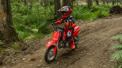 High-angle shot of the CRF50F parked on a trail, highlighting the frame and engine area.