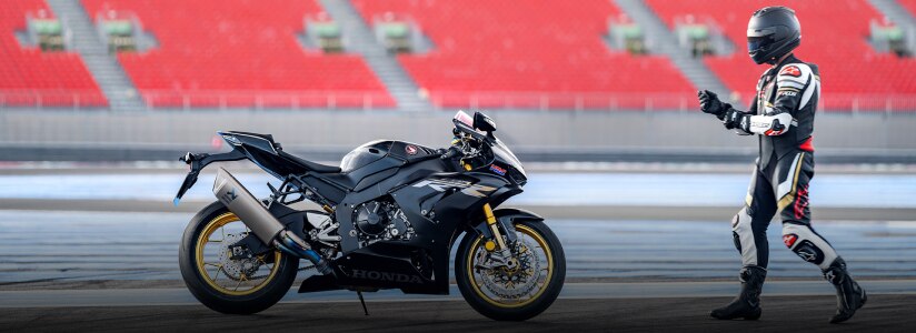 A rider walking up to a Honda motorcycle/Un cavalier marchant vers une moto Honda