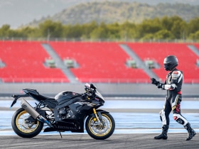 A rider walking up to a Honda motorcycle/Un cavalier marchant vers une moto Honda
