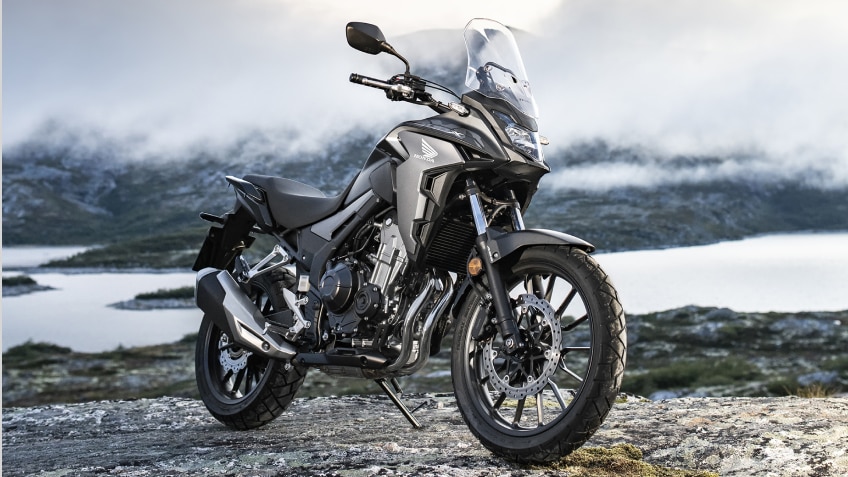 a Honda motorcycle parked in the mountains/ une moto Honda garée dans les montagnes