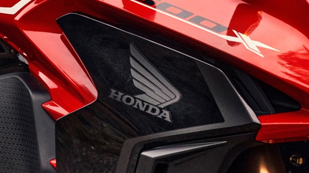 A Honda wing logo on a red motorcycle/Un logo Honda Wing sur une moto rouge
