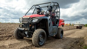 Two riders in a Pioneer on a bright day beside a farmer's field/Deux coureurs dans un pionnier un jour brillant à côté d'un champ d'agriculteur