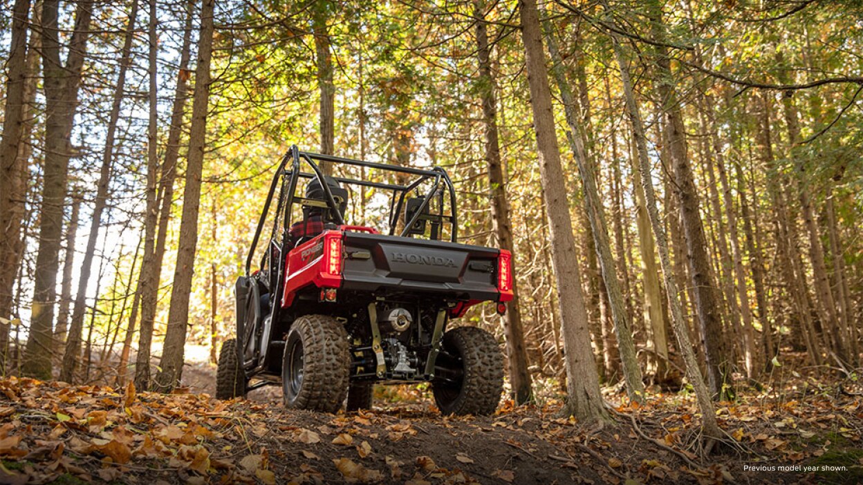 Une vue de dos d'une Honda Pioneer 520 à l'extérieur d'une forêt