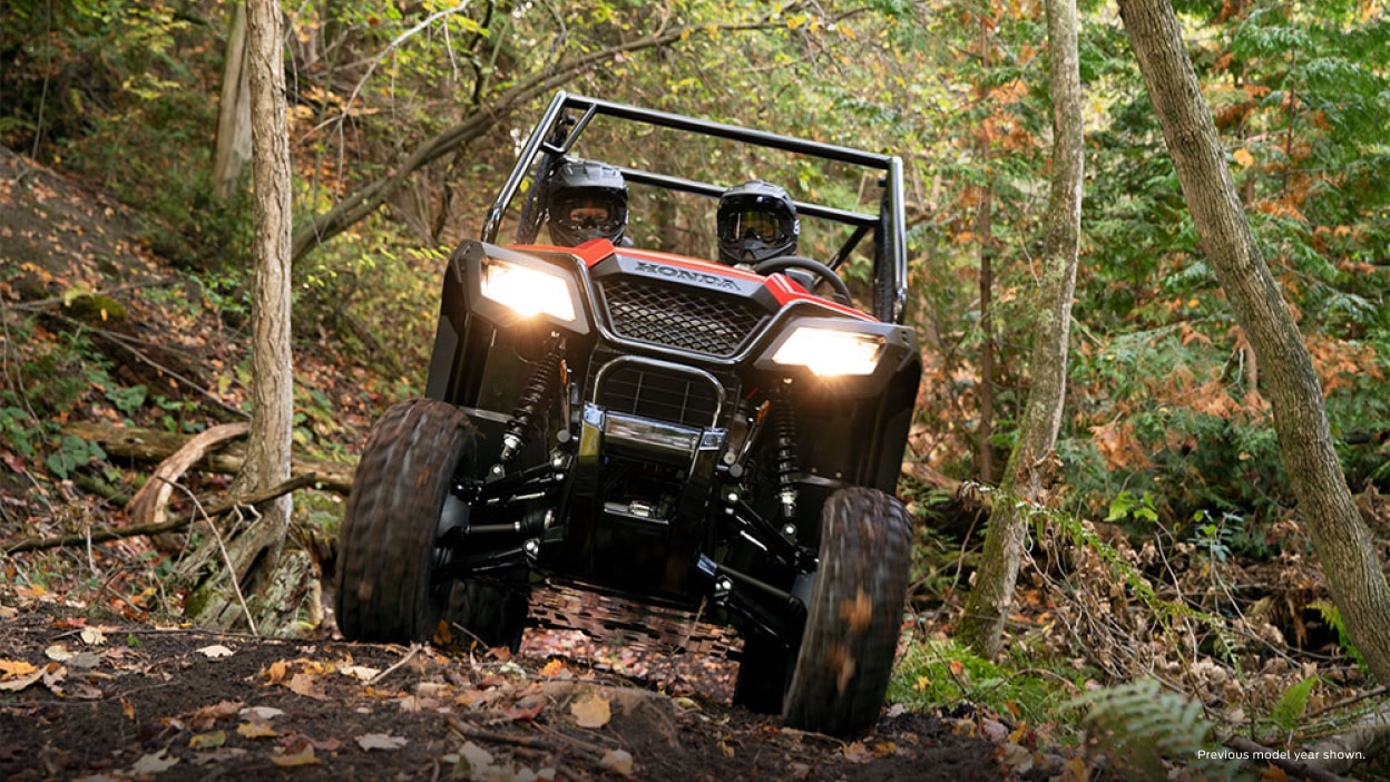 Two riders in a front facing Honda Pioneer coming down a trail