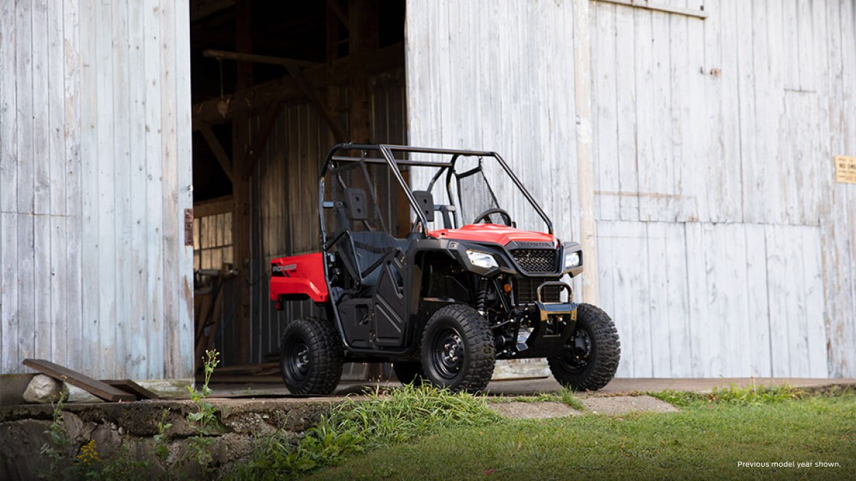 Une Honda Pioneer 520 garée à l'extérieur d'un bâtiment