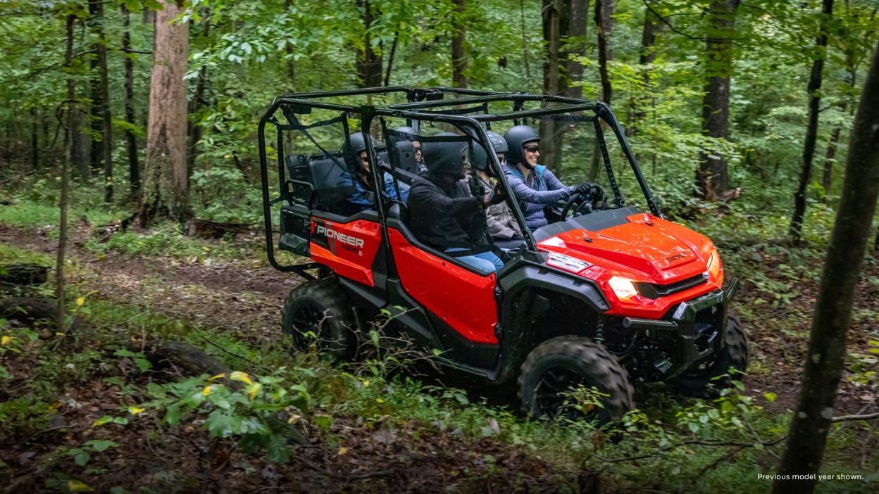 Riders in a Pioneer 1000 on a forest trail