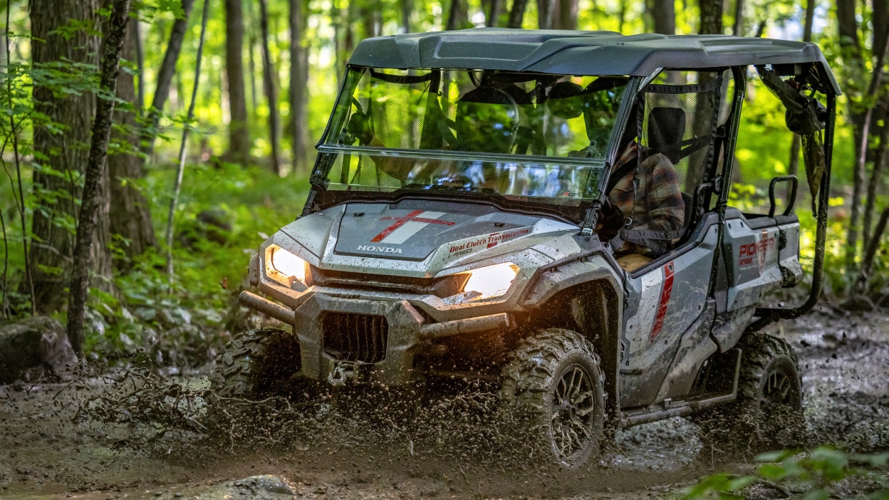 Pioneer front facing, towing trailer through forest.
